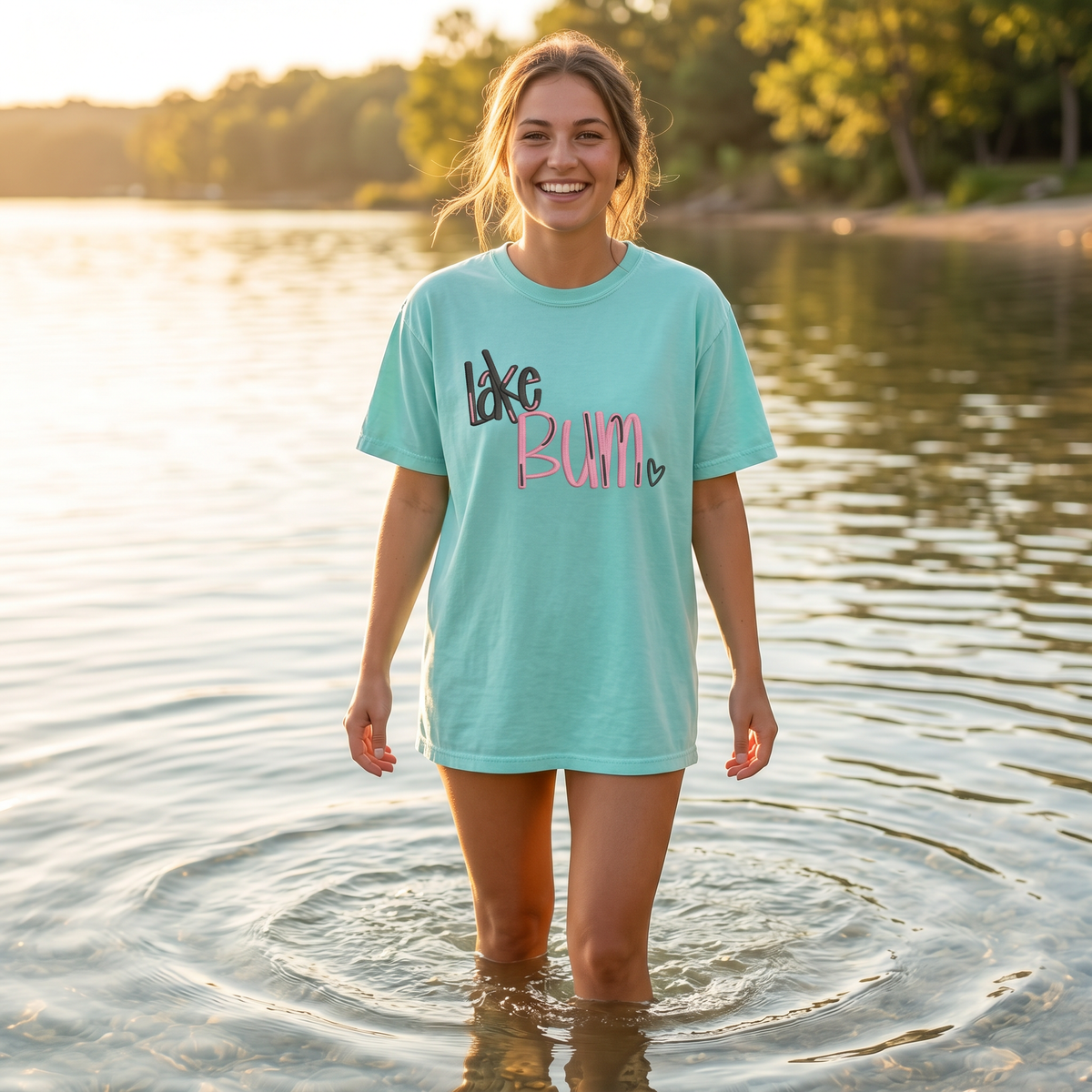 Woman standing in lake water wearing mint embroidered Lake Bum oversized summer shirt