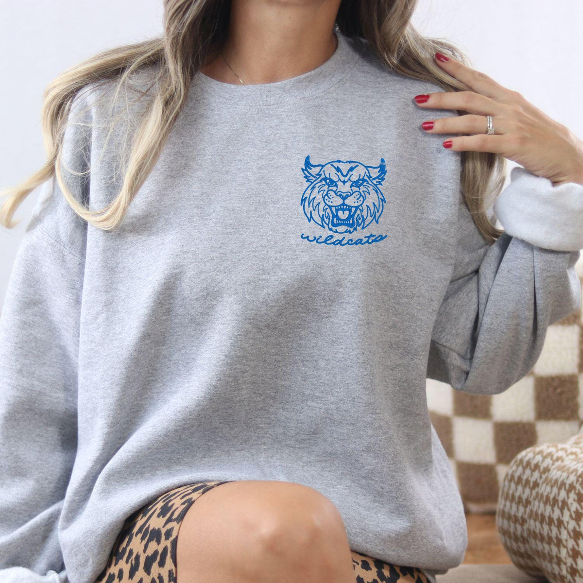 Sport gray Wildcats mascot embroidered sweatshirt modeled indoors