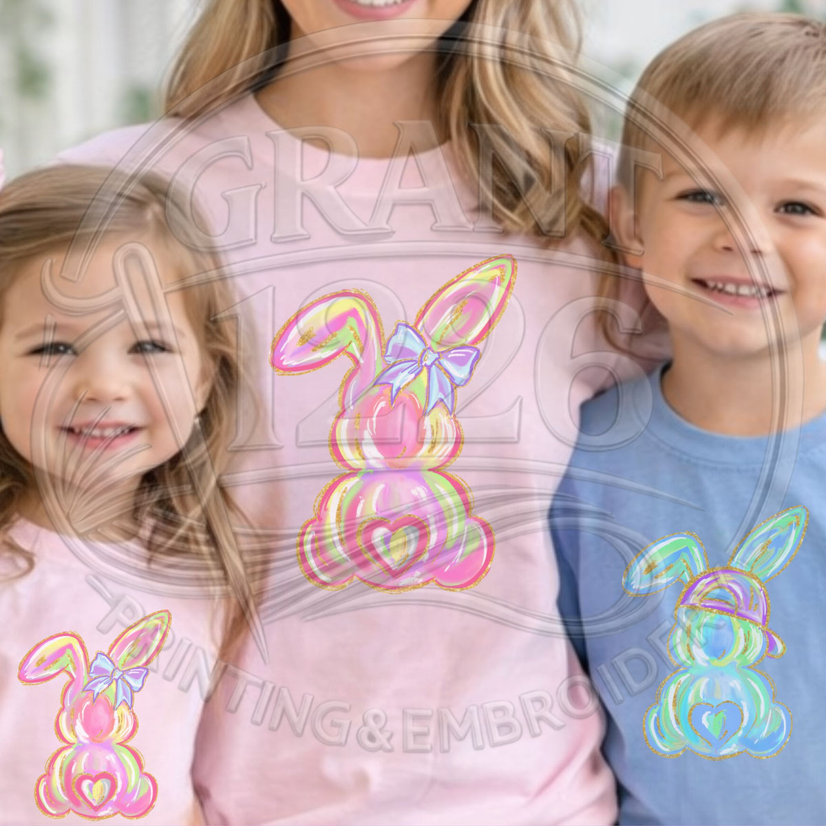 Two children and a woman wearing shirts with colorful bunny designs.