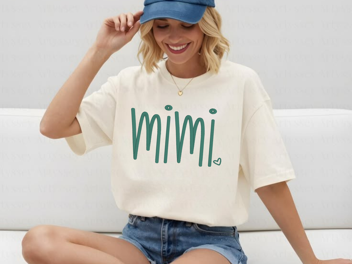 Woman wearing a white t-shirt with 'mimi' embroidered on it, sitting on a couch.