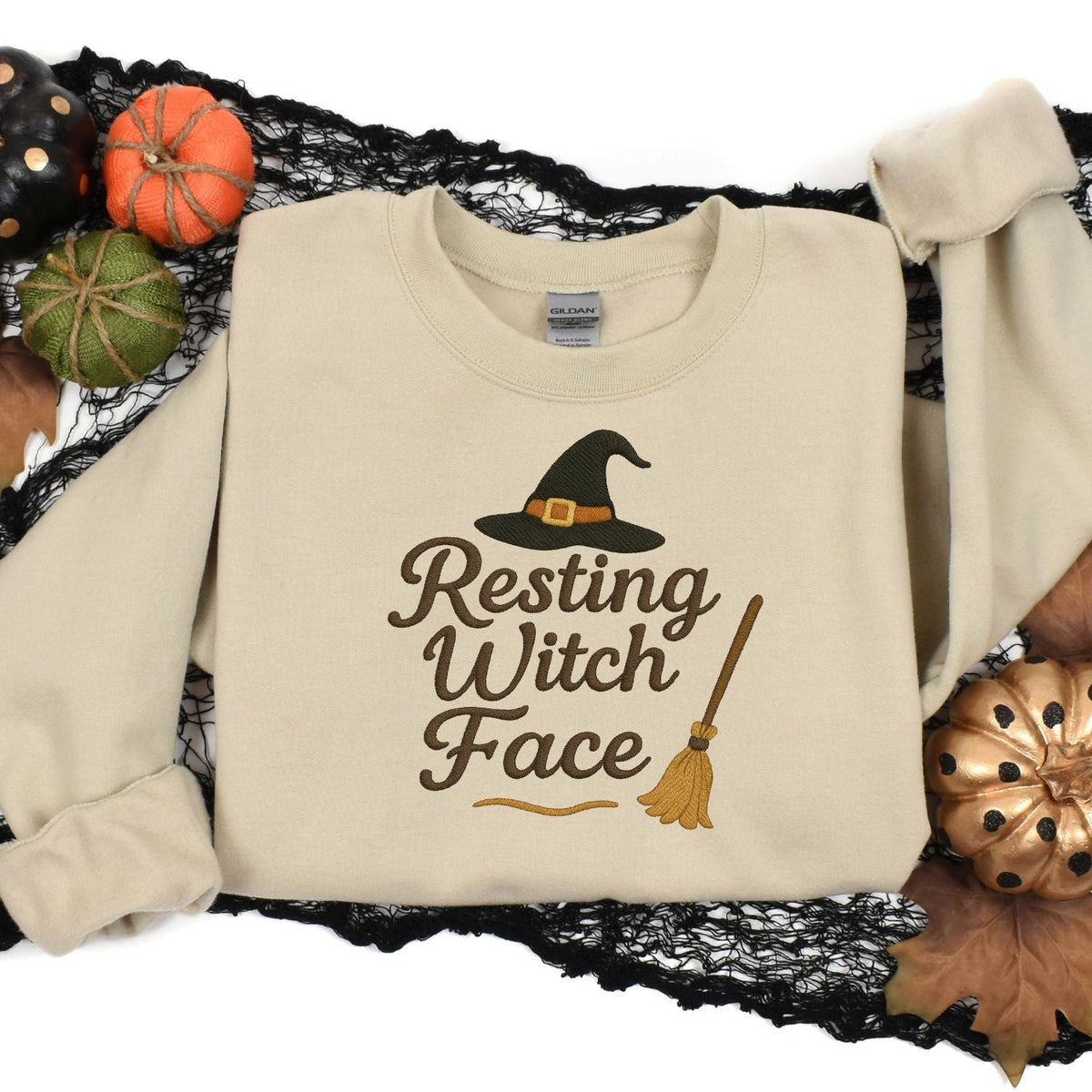 Sand Resting Witch Face embroidered sweatshirt styled with Halloween pumpkins
