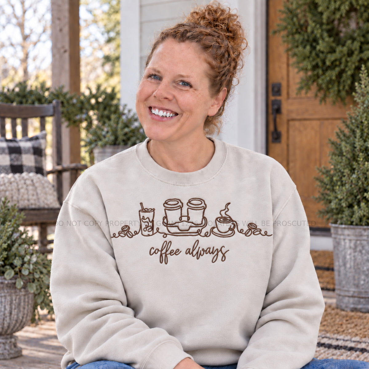 Coffee Always embroidered Gildan Softstyle sweatshirt in Sand modeled on a farmhouse porch