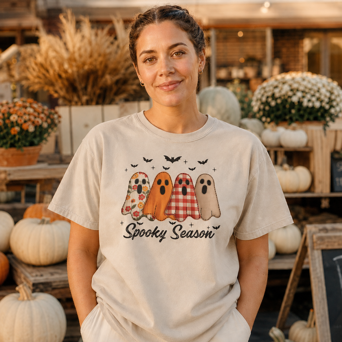 Adult woman wearing a Sandstone Comfort Colors 1717 Spooky Season ghost shirt with floral, orange, gingham and tan ghosts.