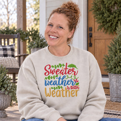 Sand Sweater Weather Is Better Weather embroidered Gildan Softstyle sweatshirt modeled on a cozy porch