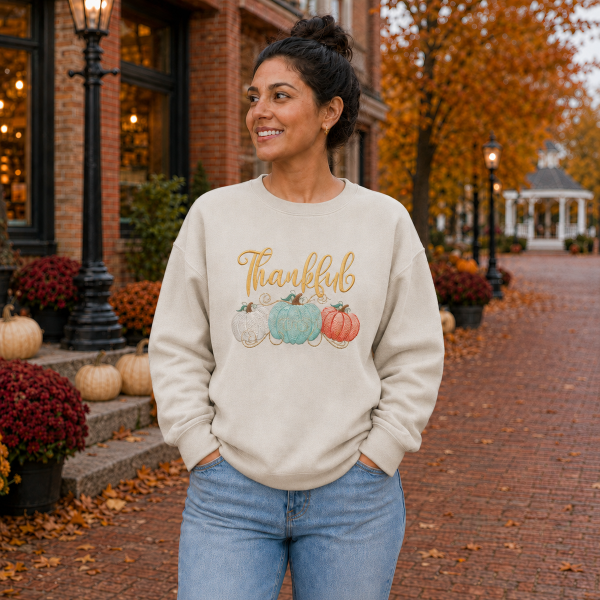 Thankful pumpkin embroidered Gildan Softstyle sweatshirt in Sand on a fall town square