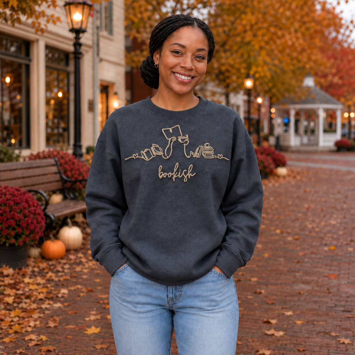 Bookish reader machine embroidery centered on a Dark Heather Gildan Softstyle sweatshirt, approximately 10 inches wide