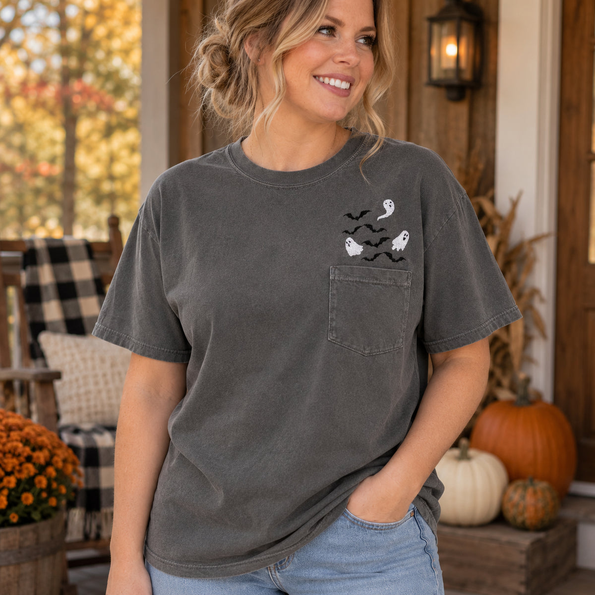 Woman wearing a Pepper Comfort Colors pocket T-shirt with white ghost and black bat embroidery above the chest pocket