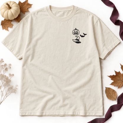 Ivory heavyweight T-shirt flat lay with black jack-o-lantern, two bats, and witch hat embroidery.