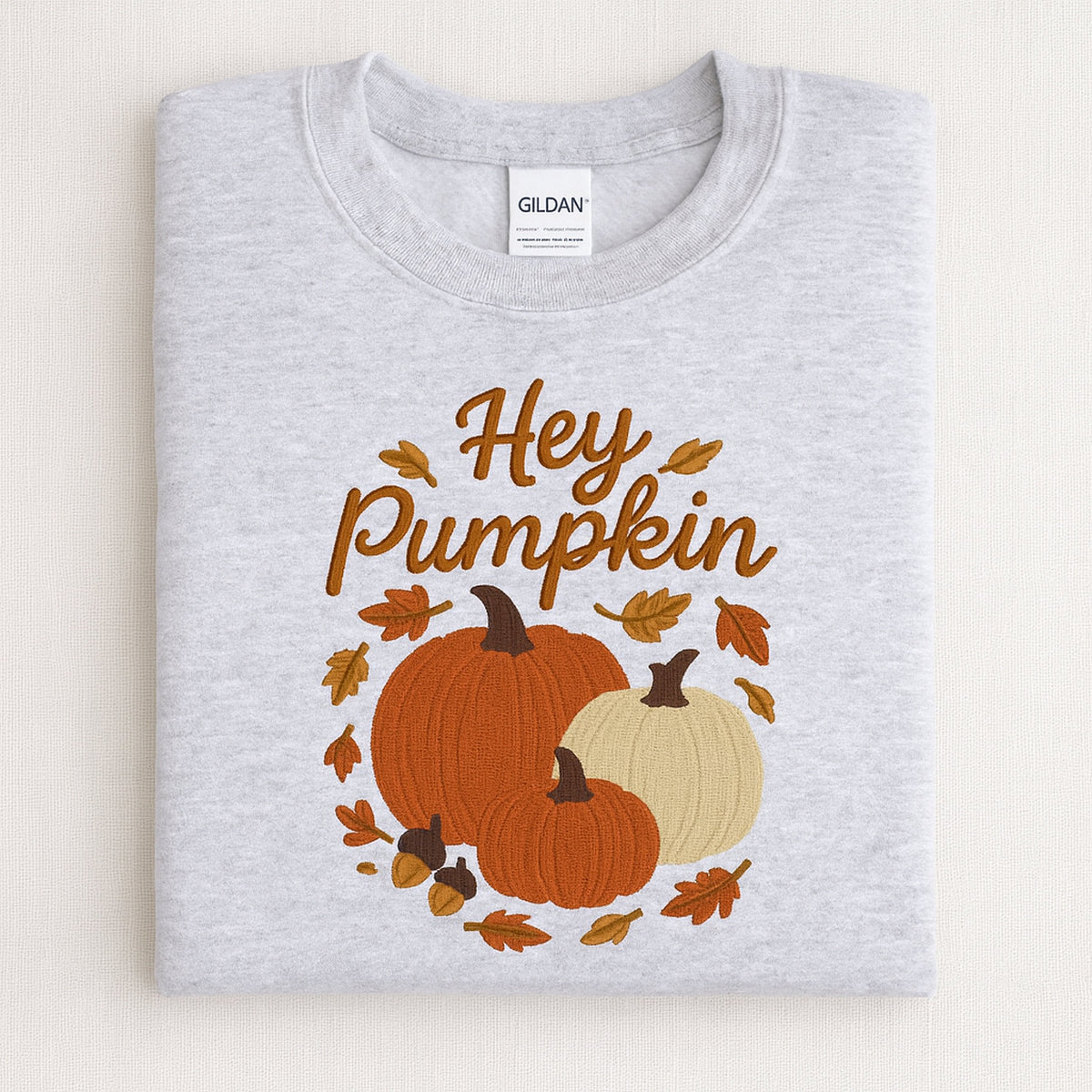 Ash Hey Pumpkin embroidered sweatshirt with three autumn pumpkins in a seasonal flat lay