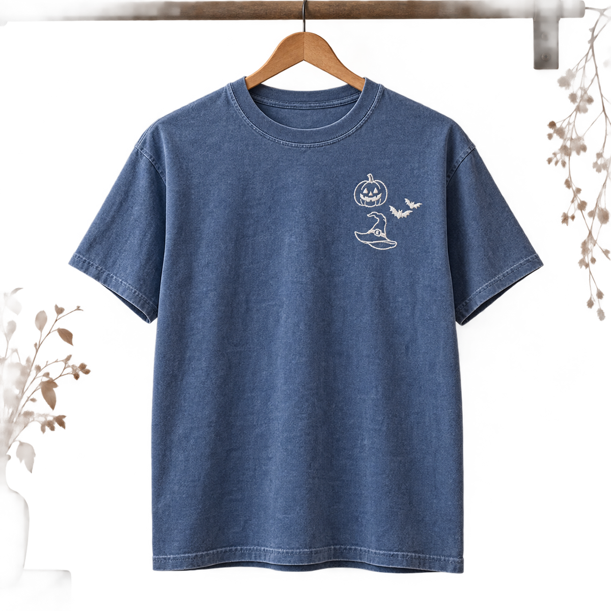 Blue Jean garment-dyed T-shirt hanging with white Halloween embroidery on the left chest.