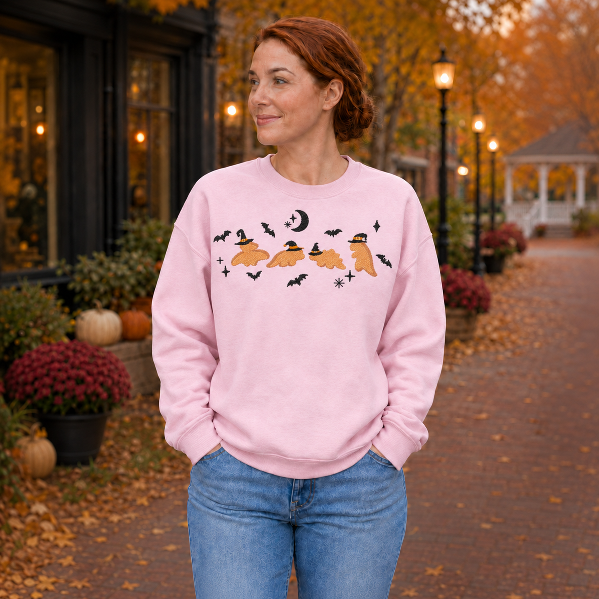 Woman wearing a Light Pink Dinosaur Witches embroidered Halloween crewneck