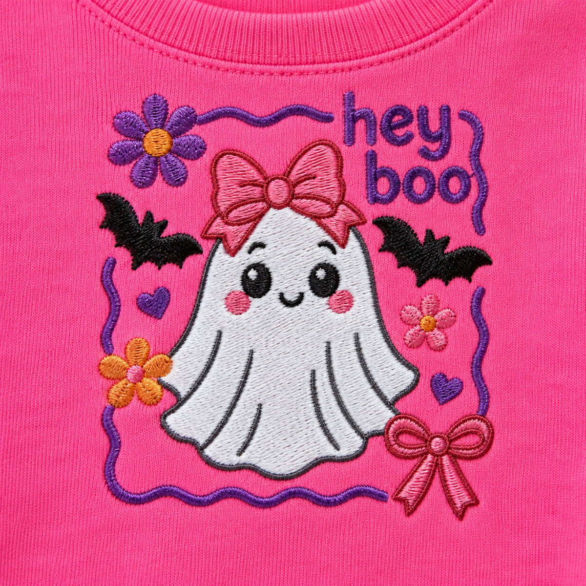 Close-up of Hey Boo ghost machine embroidery with purple pink orange and black thread