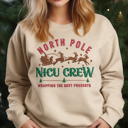 Close view of North Pole NICU Crew Christmas embroidery on a Sand sweatshirt