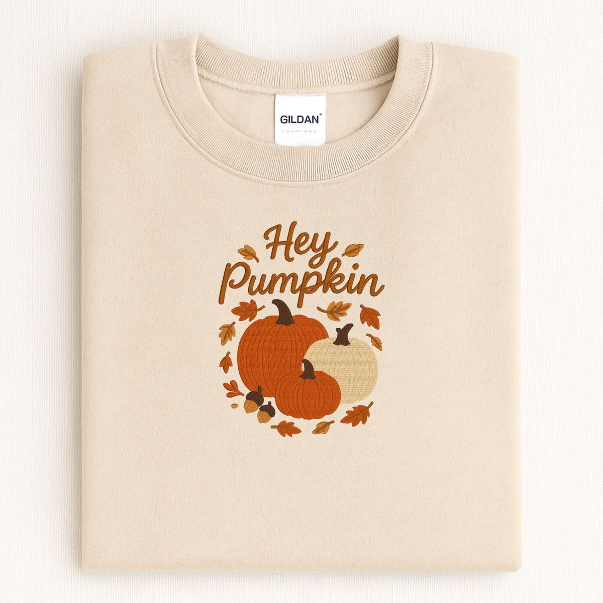 Sand Hey Pumpkin sweatshirt with three embroidered pumpkins in a cozy fall flat lay