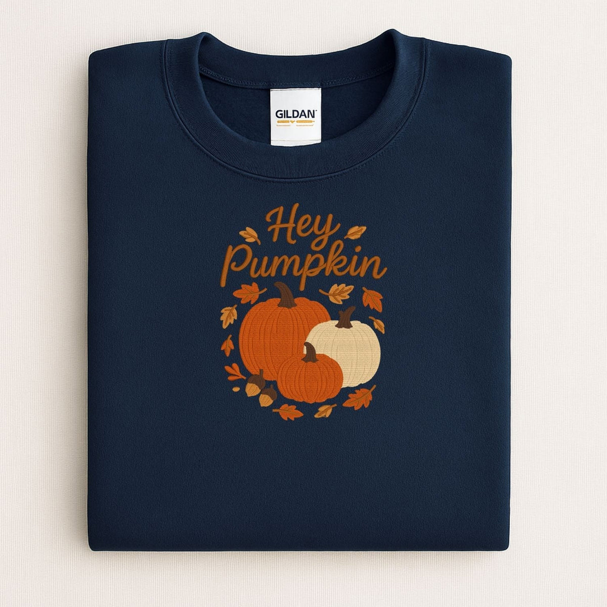 Navy Hey Pumpkin embroidered sweatshirt displayed in an autumn flat lay