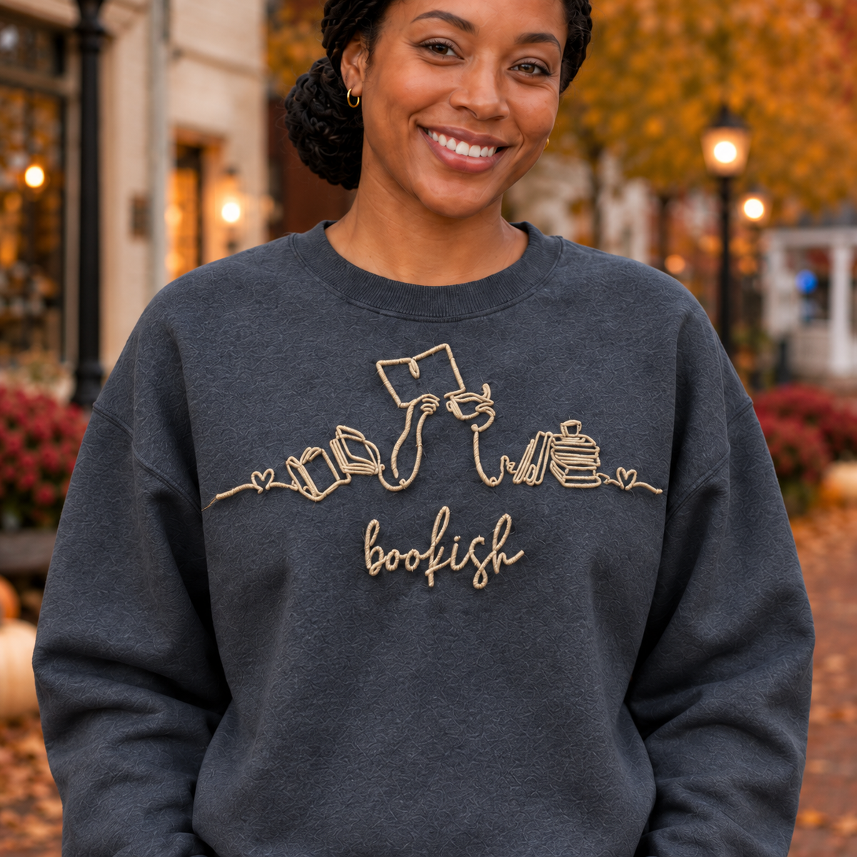 Close-up of warm cream Bookish machine embroidery and stitch texture on a Dark Heather sweatshirt