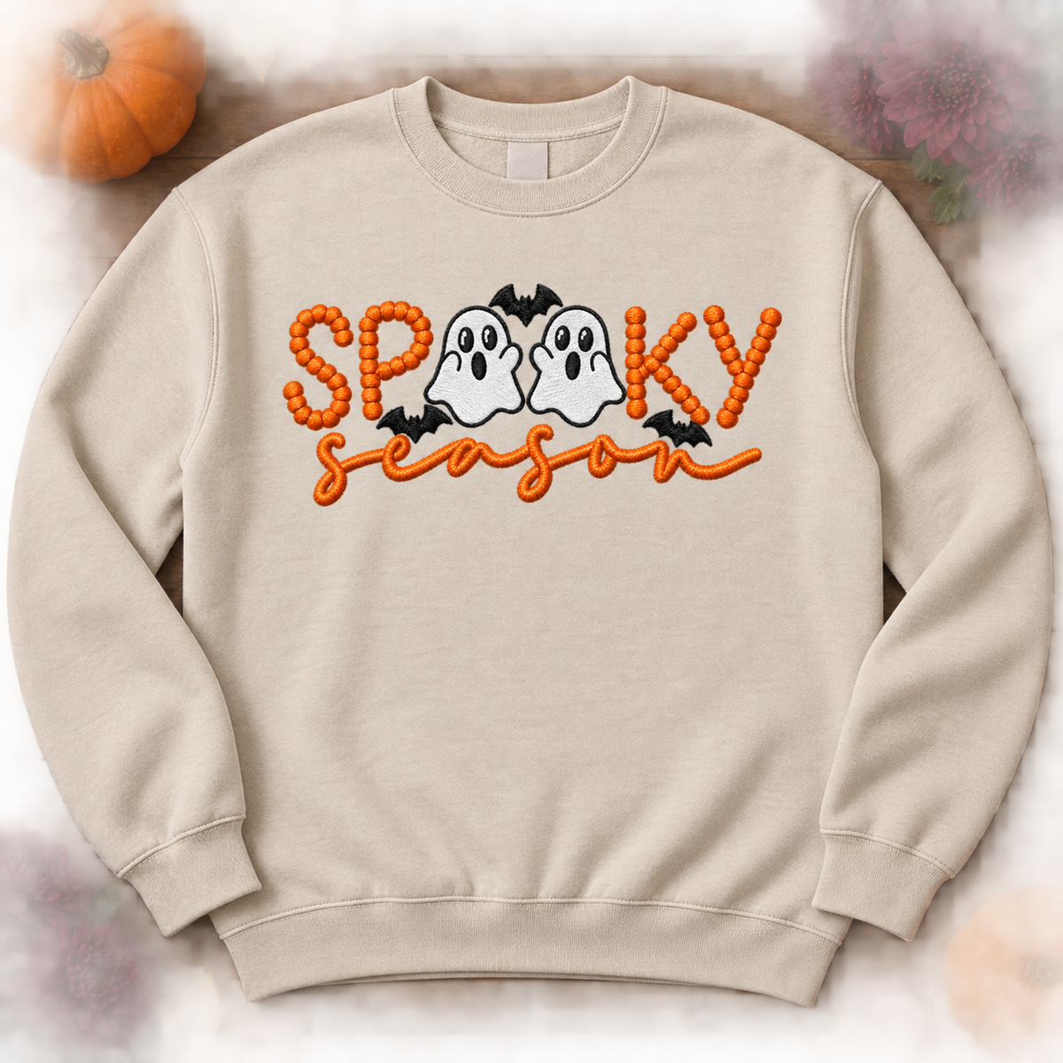 Sand Spooky Season ghost embroidered sweatshirt flat lay with pumpkins and fall flowers