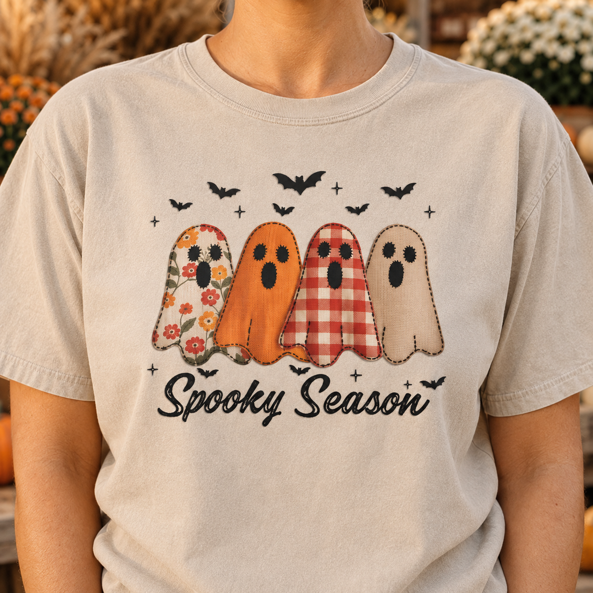 Close-up of the Spooky Season DTG print showing four patterned ghosts and black script on a Sandstone shirt.