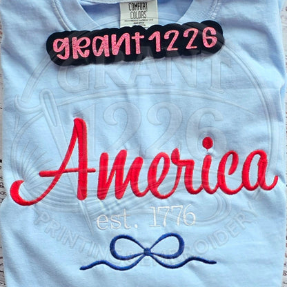 Closeup embroidery detail of America Est 1776 patriotic shirt