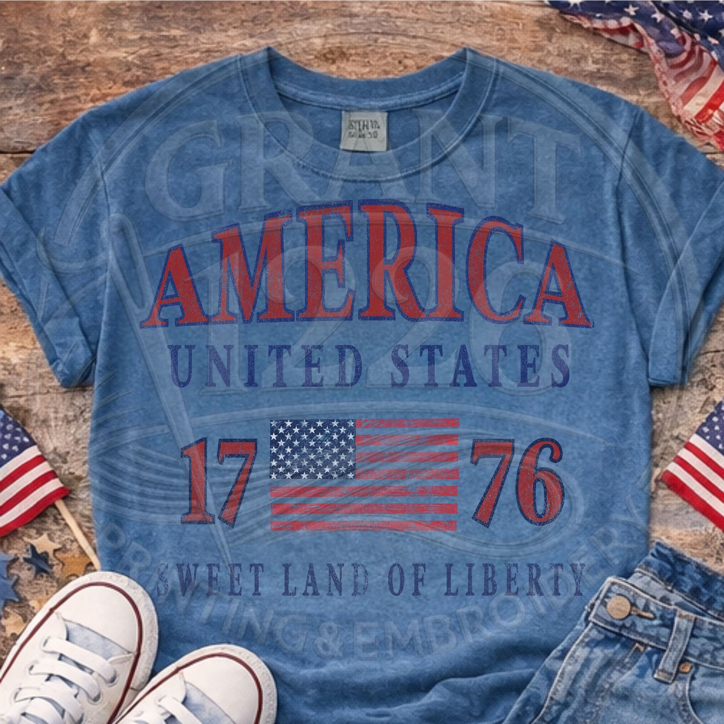 Blue America 1776 patriotic Comfort Colors shirt flat lay with USA flags and denim shorts