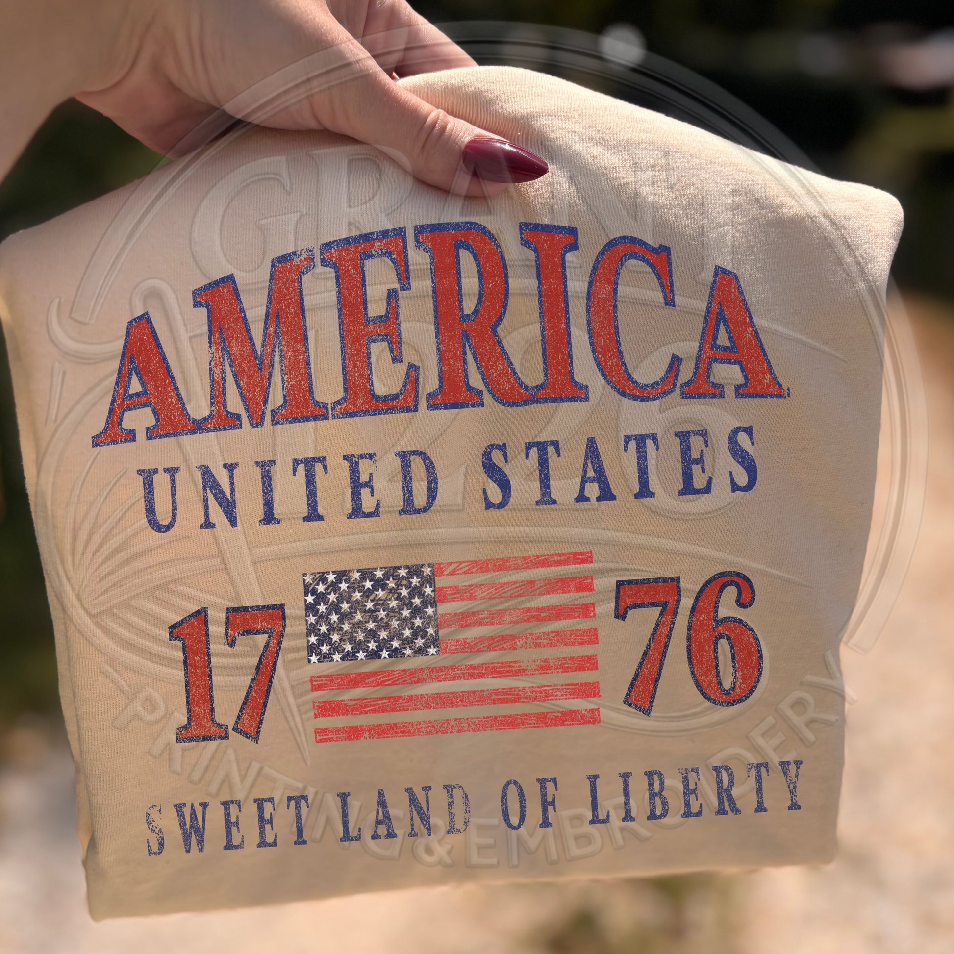 Close up of ivory patriotic America 1776 shirt with distressed USA flag graphic design