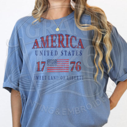 Woman wearing blue America 1776 patriotic graphic tee with vintage USA flag design