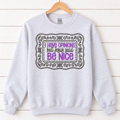 Ash Gildan Softstyle embroidered Be Nice sweatshirt on a natural wood hanger