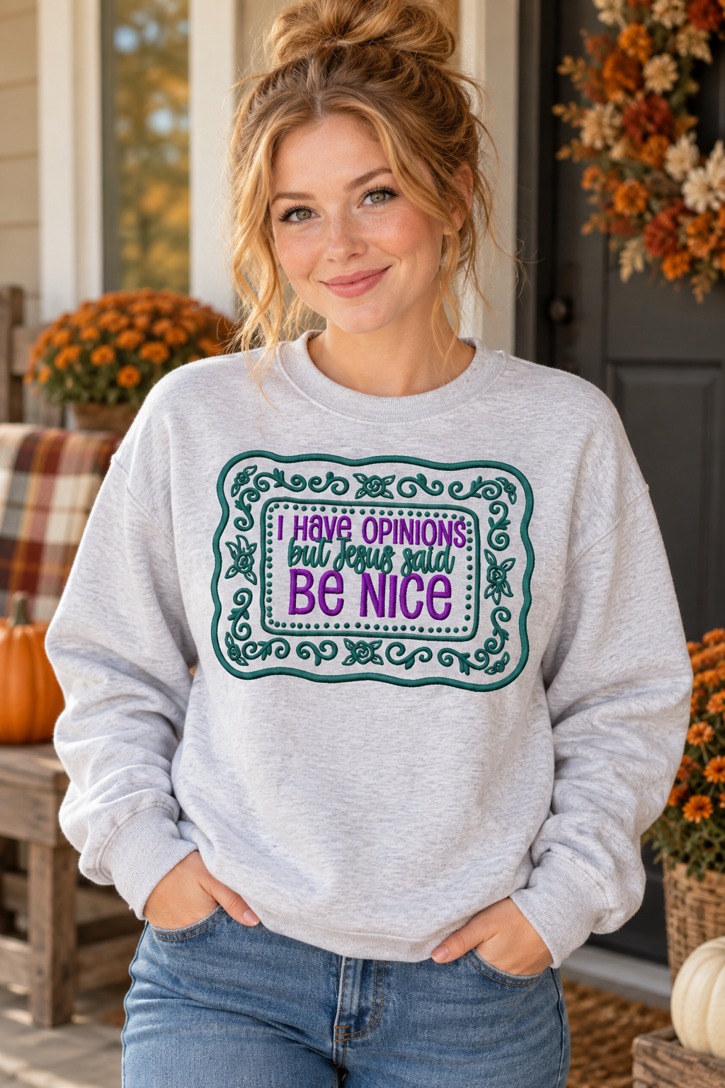 Woman modeling Ash embroidered I Have Opinions But Jesus Said Be Nice sweatshirt on a fall porch