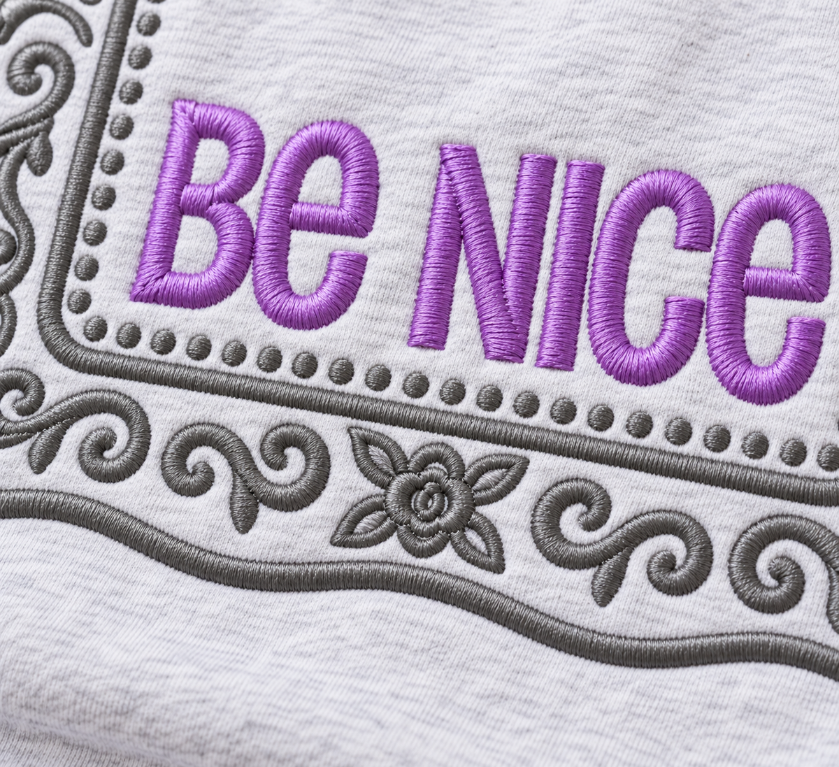 Close-up of lavender and grey raised embroidery on Ash Be Nice sweatshirt