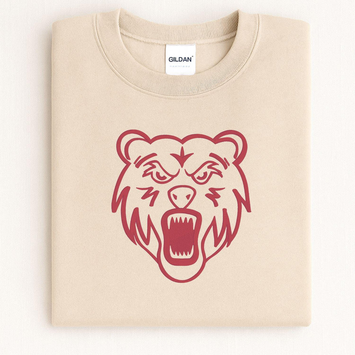 Sand bear mascot embroidered crewneck folded on a light background