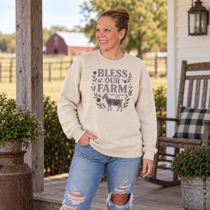 Samantha wearing sand Bless Our Farm Christian sweatshirt on a farm porch