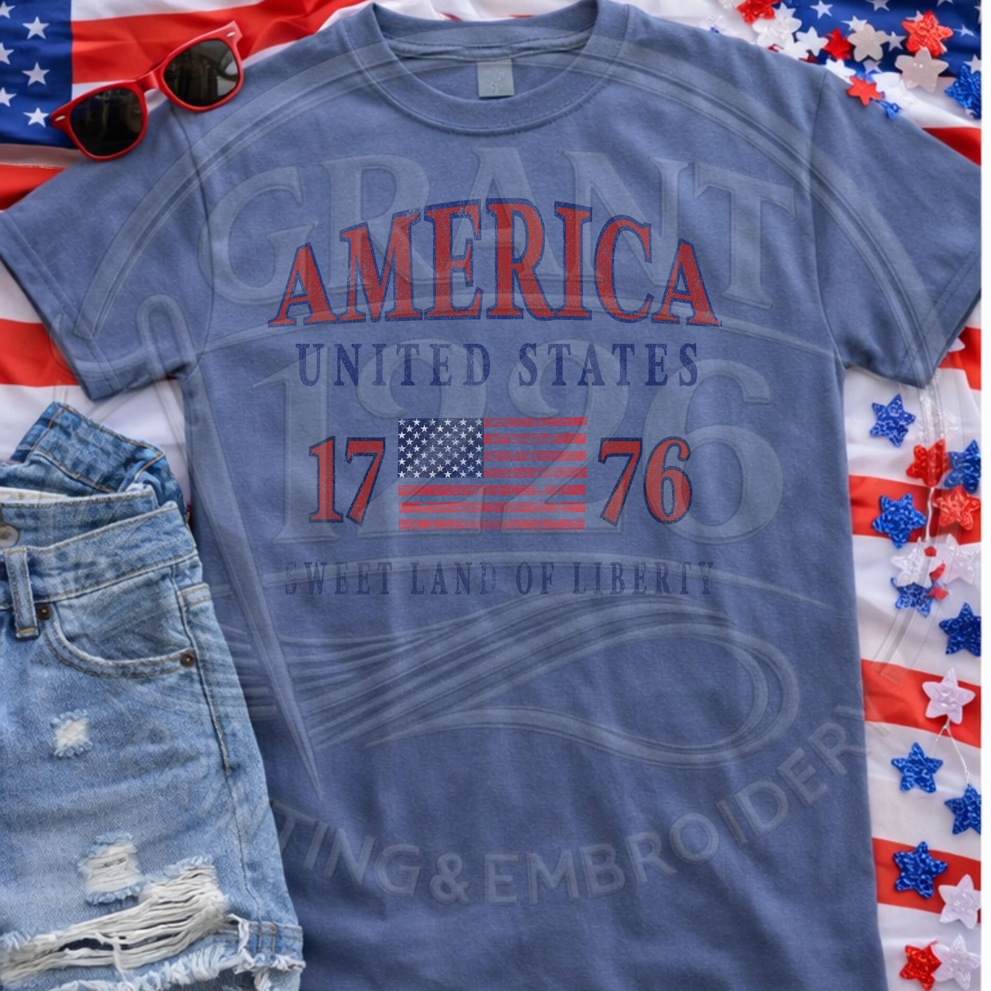 Blue patriotic America 1776 Comfort Colors shirt flat lay with Fourth of July accessories