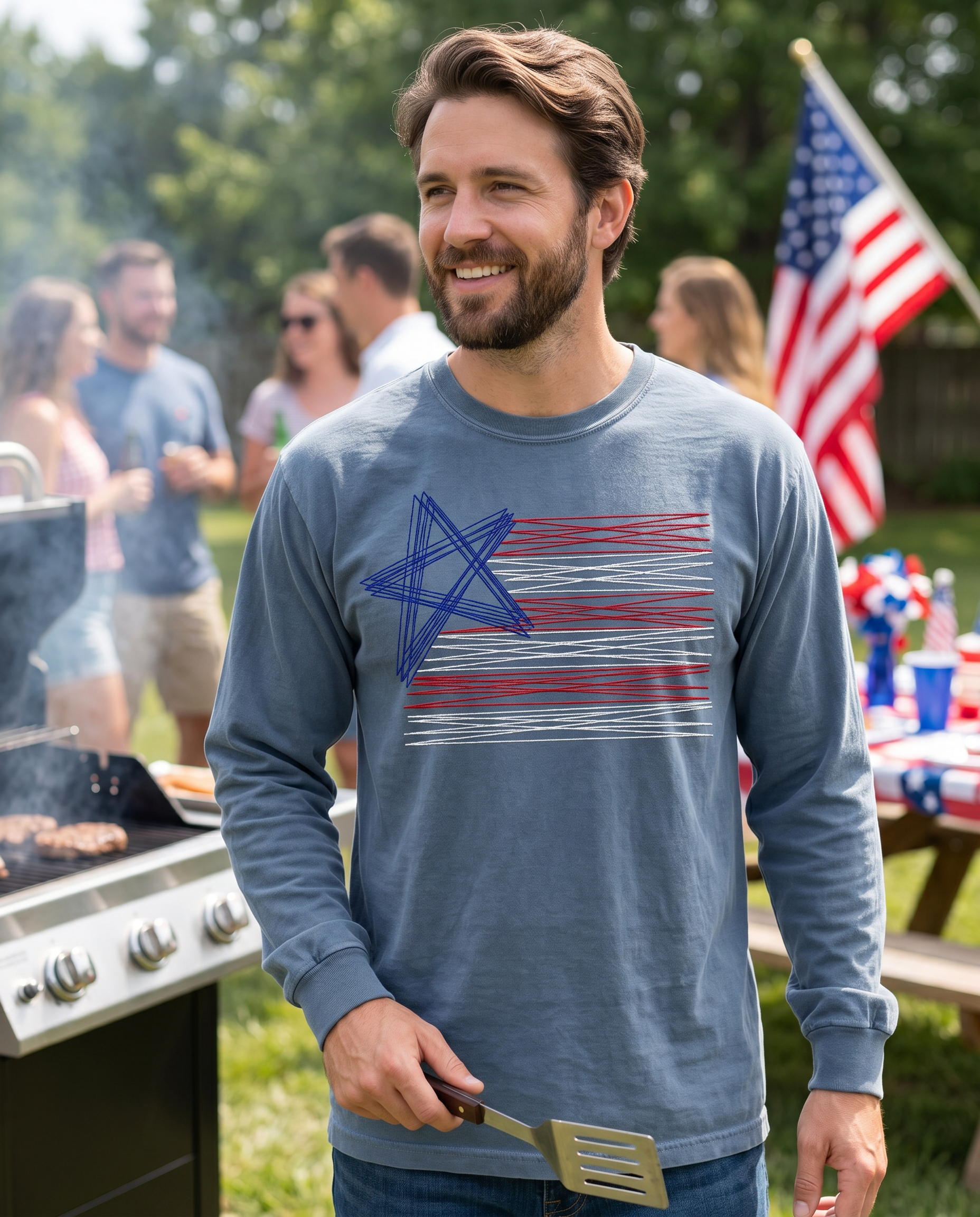 Man grilling outdoors wearing blue embroidered patriotic American flag long sleeve shirt