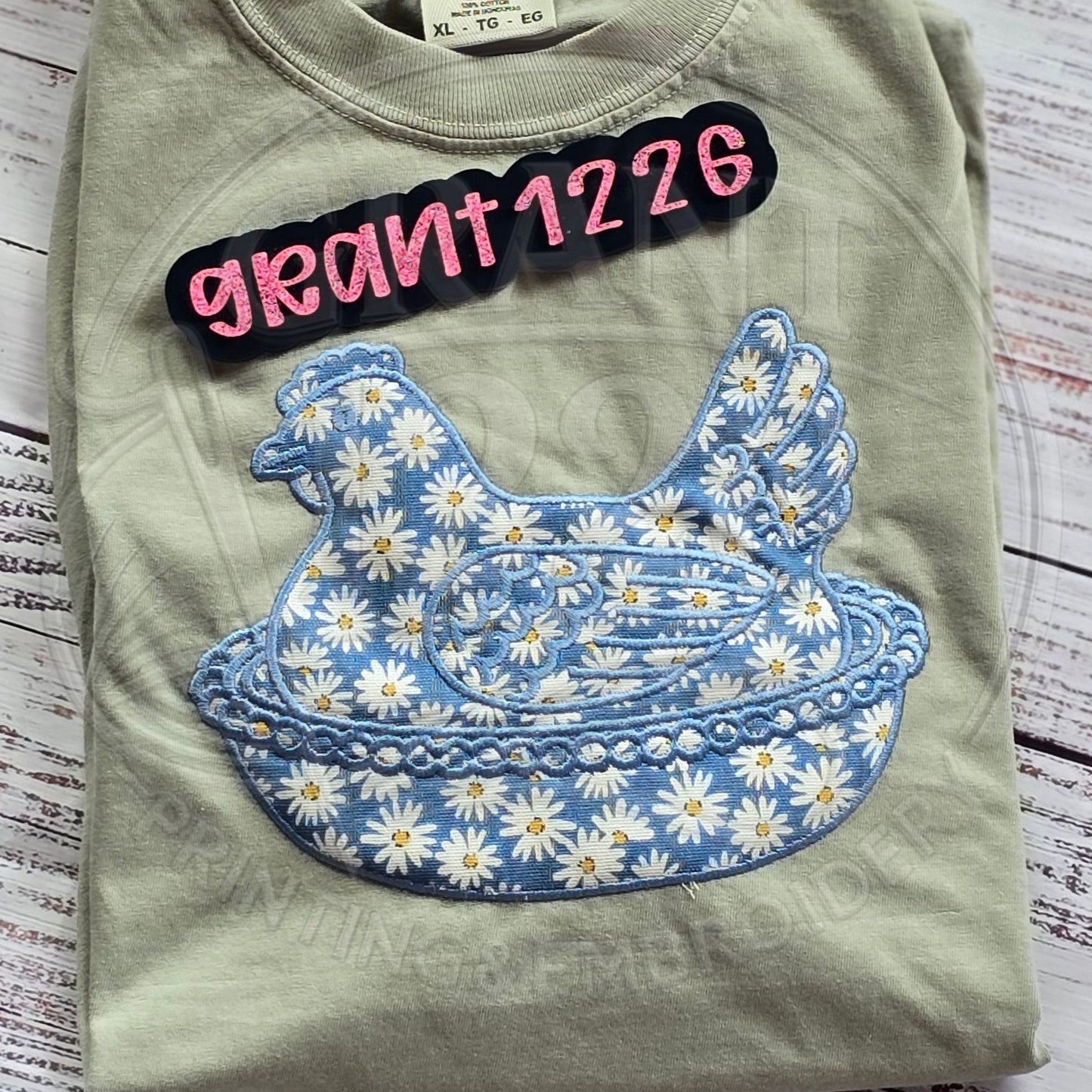 Blue daisy chicken applique embroidered Comfort Colors khaki t-shirt flat lay