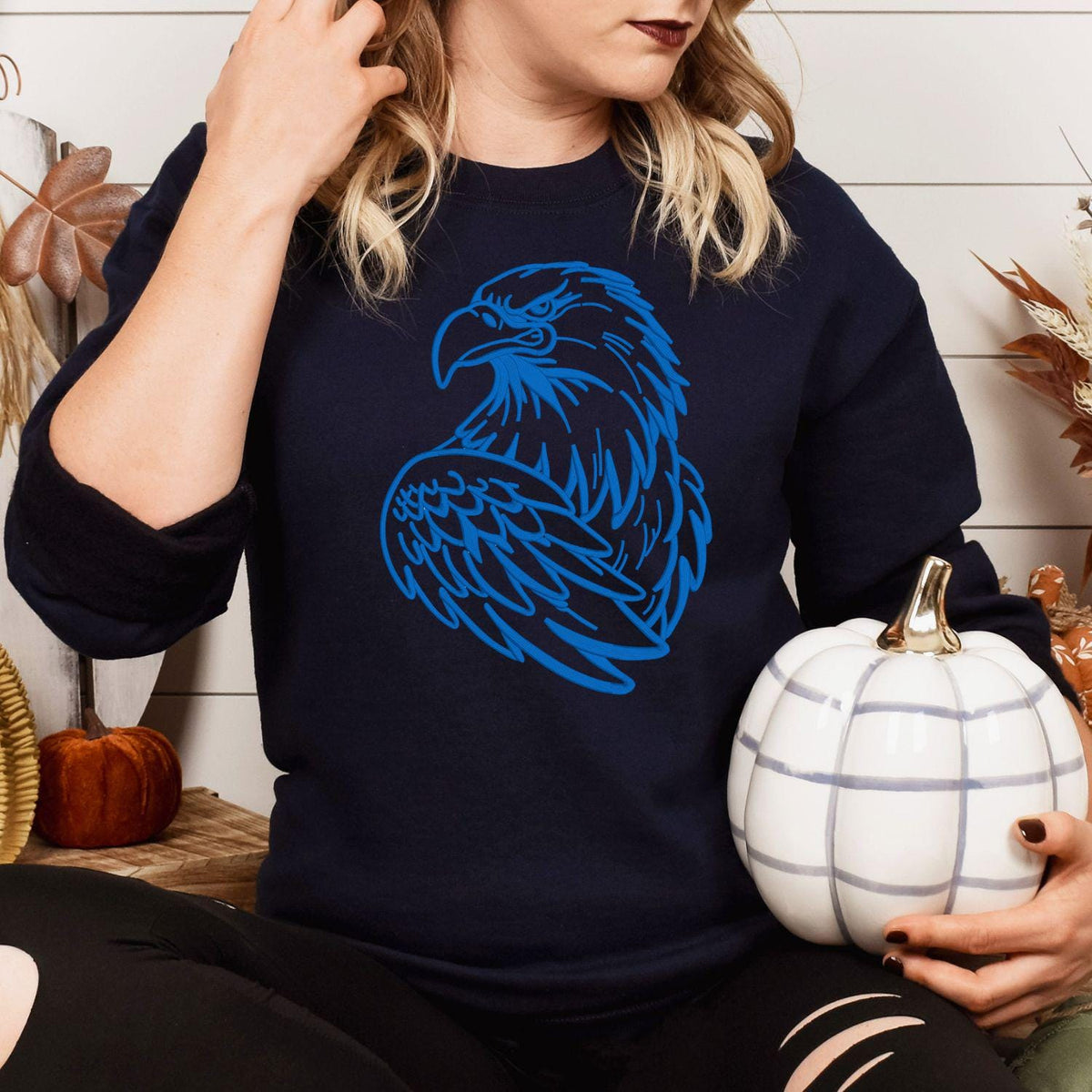 Navy eagle mascot sweatshirt modeled while holding a white pumpkin