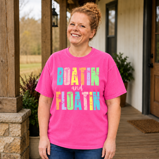 Samantha wearing a Neon Pink Comfort Colors shirt with colorful distressed Boatin and Floatin print