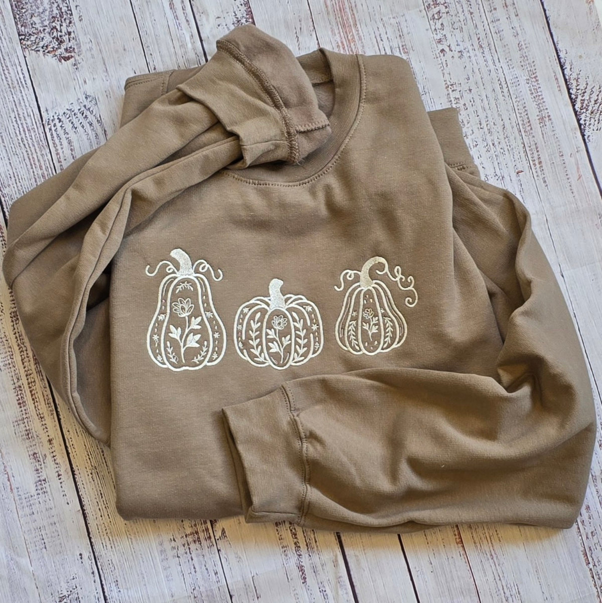 Brown Savana Gildan Softstyle sweatshirt with cream botanical pumpkin trio embroidery flat lay
