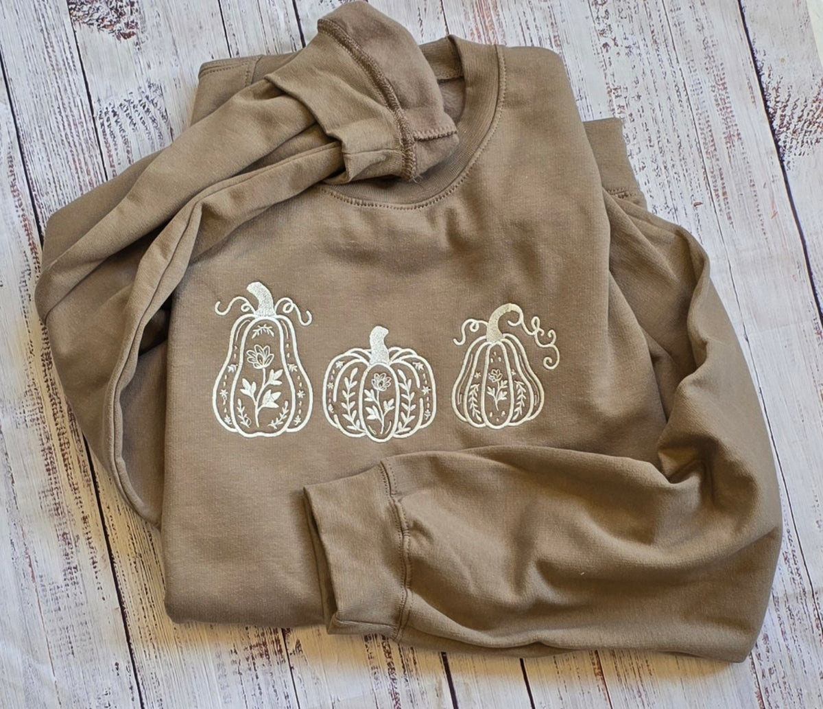 Brown Savana embroidered fall sweatshirt with three cream floral pumpkins folded flat lay