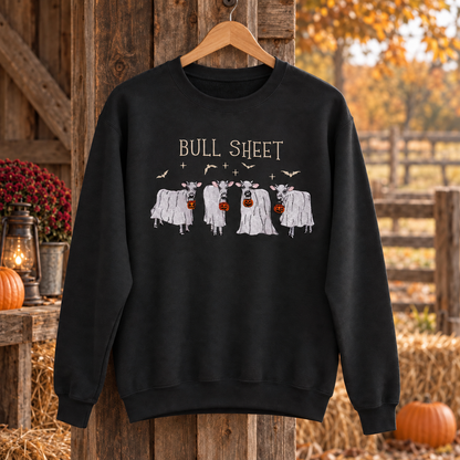 Black Bull Sheet cow ghost embroidered sweatshirt hanging in an autumn barn, with cream lettering and bats