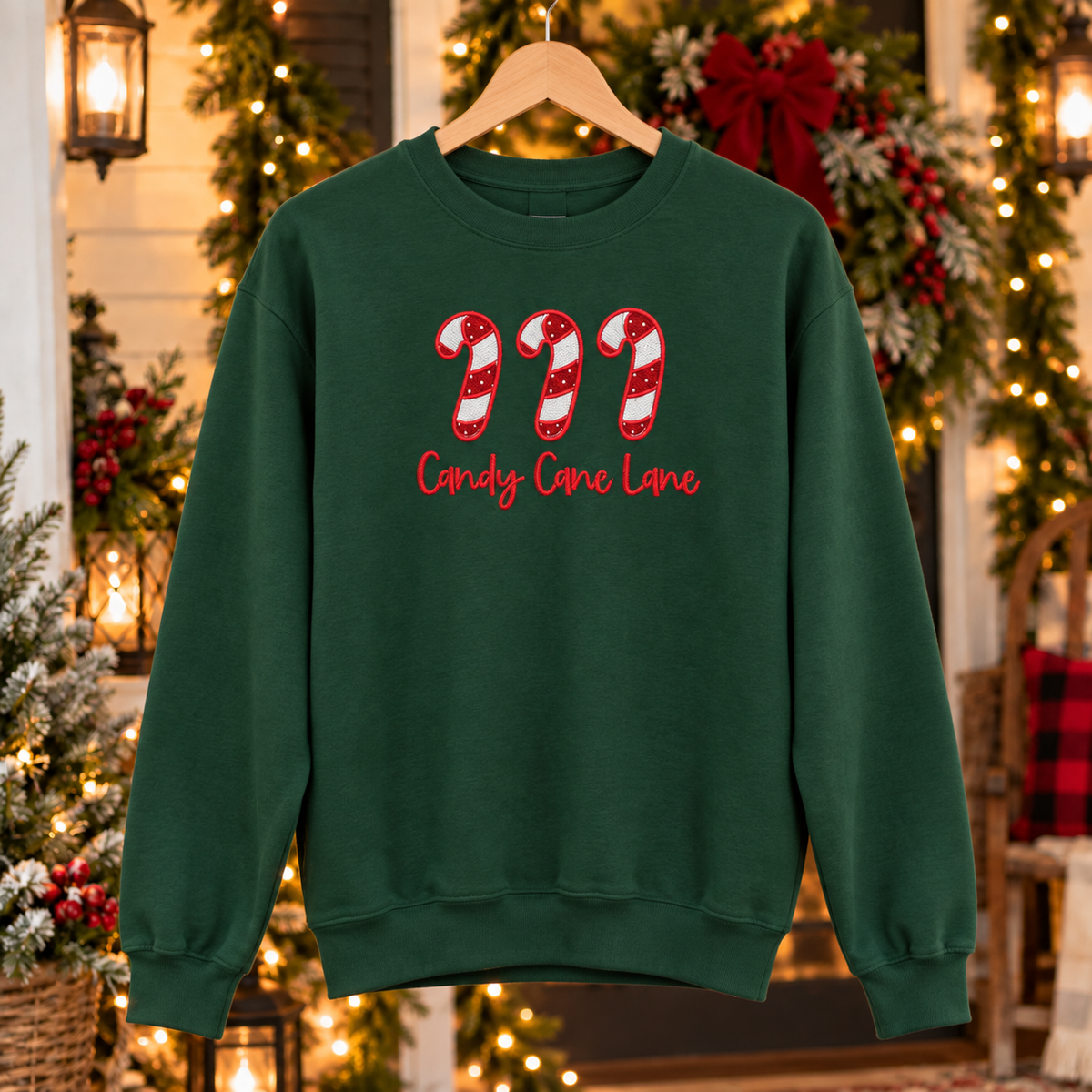 Forest Green Candy Cane Lane embroidered sweatshirt on Christmas porch hanger