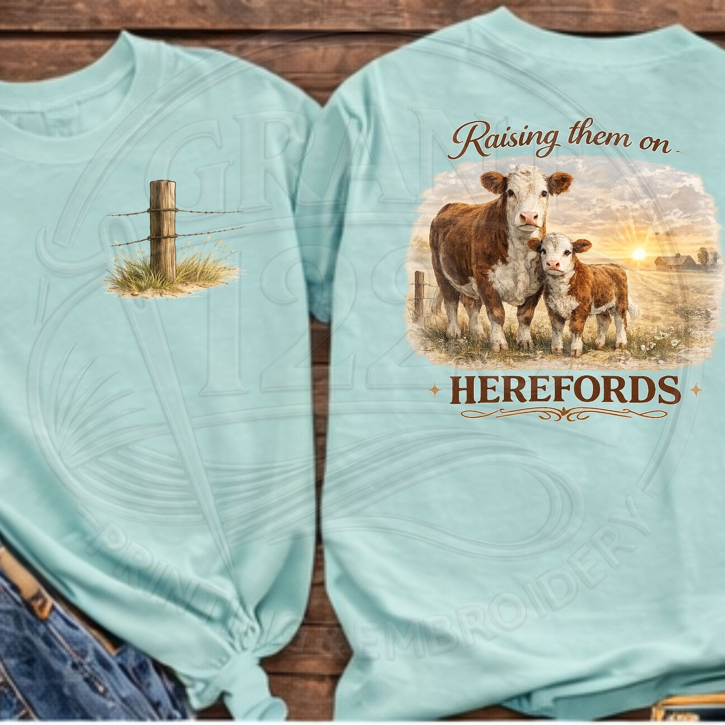Light blue t-shirt with a graphic of cows and text 'Raising them on Herefords' 