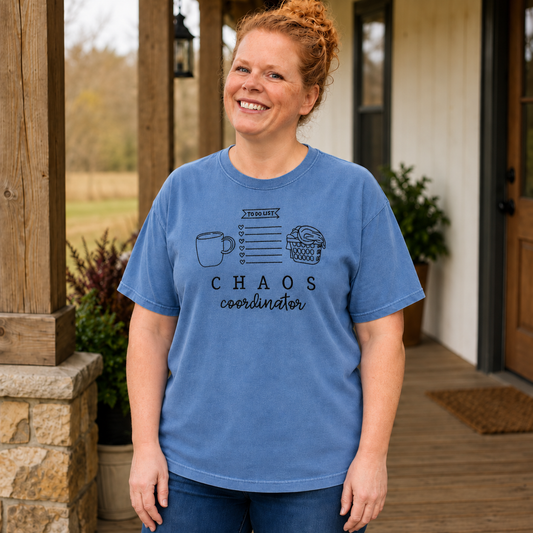 Samantha wearing a Blue Jean Comfort Colors shirt with black Chaos Coordinator embroidery