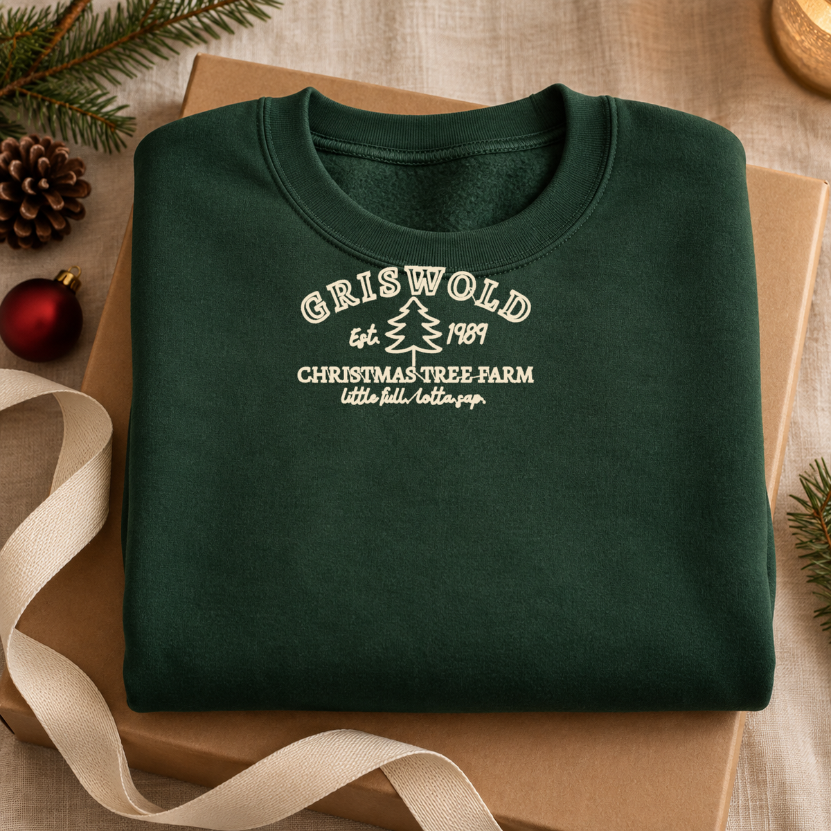 Folded forest green embroidered Christmas sweatshirt styled as a cozy holiday gift