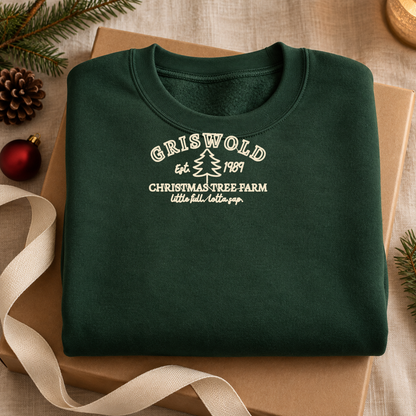 Folded forest green embroidered Christmas sweatshirt styled as a cozy holiday gift