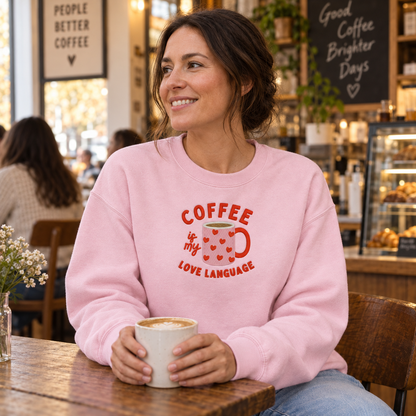 Woman wearing Light Pink Gildan Softstyle sweatshirt with coffee love language embroidery
