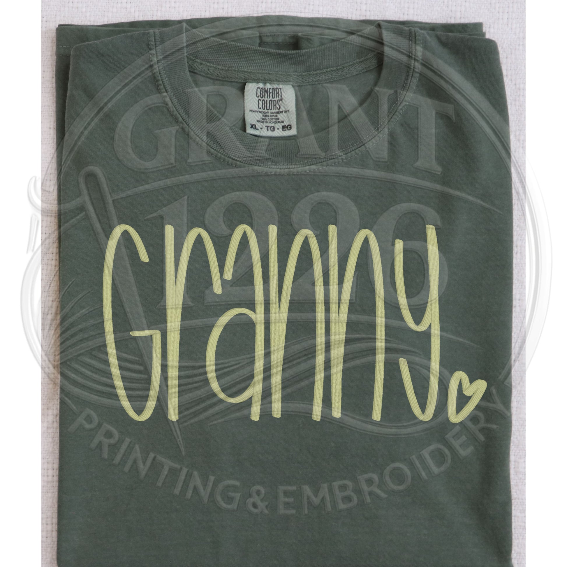 Moss green granny embroidered Comfort Colors shirt folded flat lay