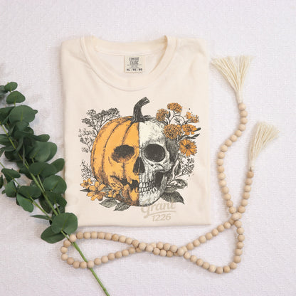 Comfort Colors Ivory floral pumpkin skull shirt styled with greenery and wood beads