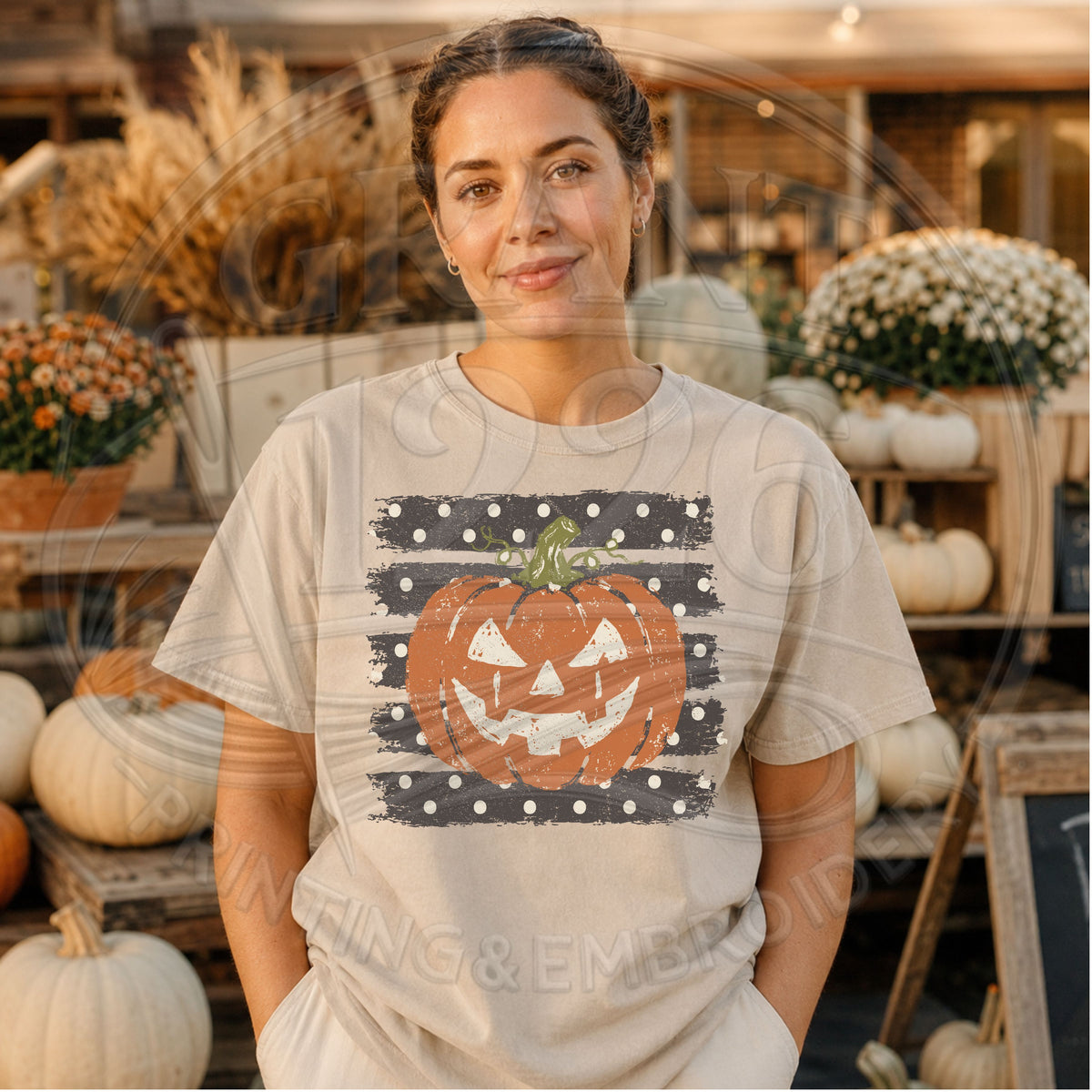Woman wearing a sandstone Comfort Colors jack o lantern Halloween shirt with vintage distressed pumpkin graphic at a fall pumpkin stand