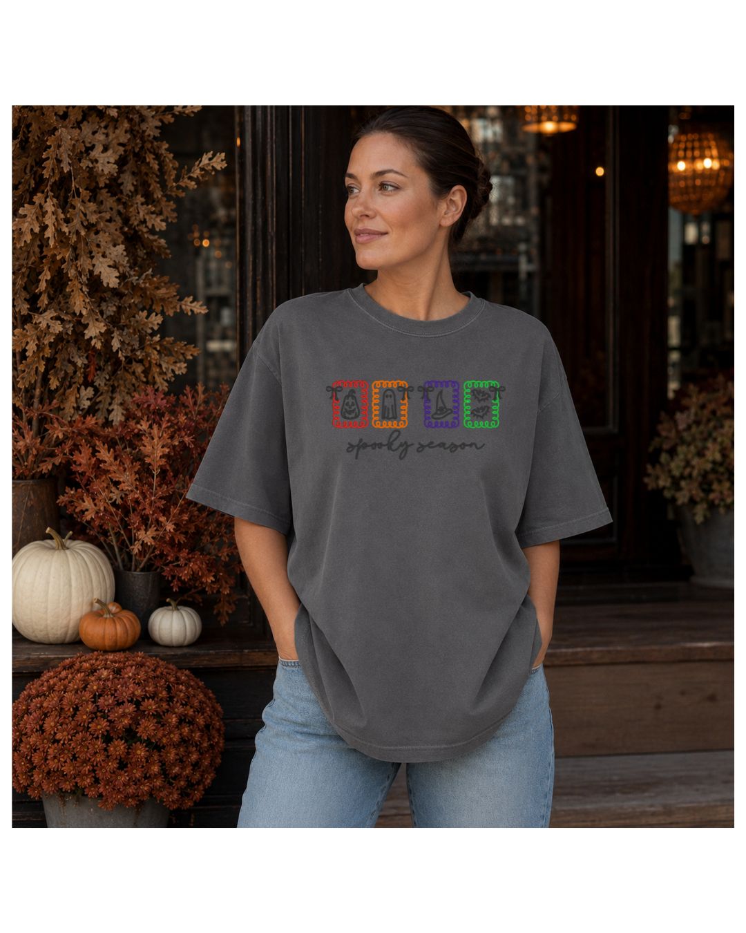 Woman wearing a Pepper Comfort Colors short-sleeve shirt embroidered with colorful Spooky Season Halloween icons