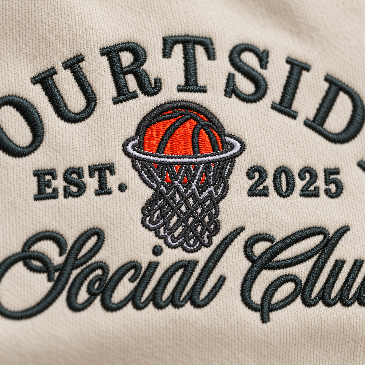 Close-up of Courtside Social Club basketball embroidery stitches on Sand sweatshirt